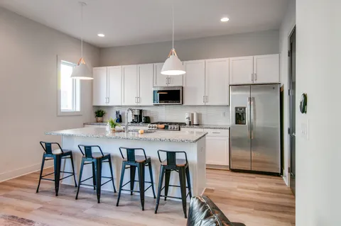 a kitchen with granite countertop a sink and a stove top oven