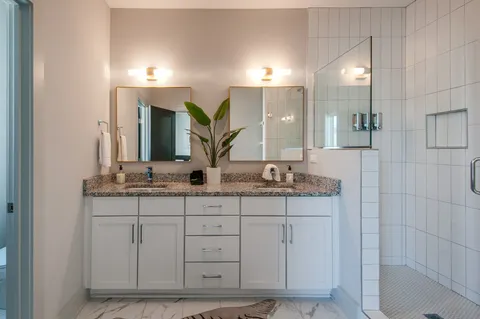 a bathroom with a granite countertop shower and a sink