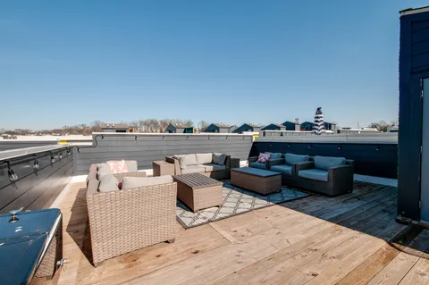 a view of a patio with couches chairs potted plants and city view