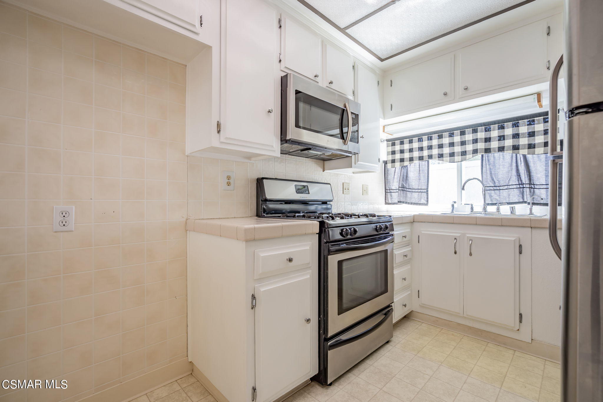 6392 Katherine Road, Unit C Simi Valley, CA 93063 - Photo 13 of 31 a kitchen with stainless steel appliances white cabinets and a stove top oven