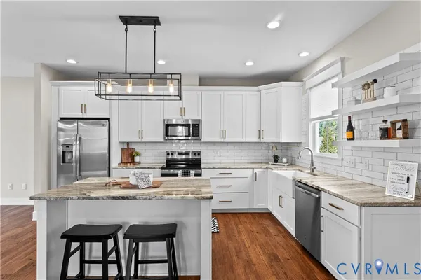 a kitchen with granite countertop a sink a stove and cabinets