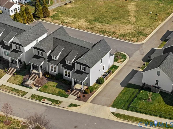 an aerial view of residential houses with outdoor space and parking