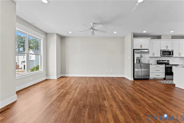 a view of empty room with wooden floor and window