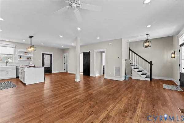a view of an empty room with wooden floor windows