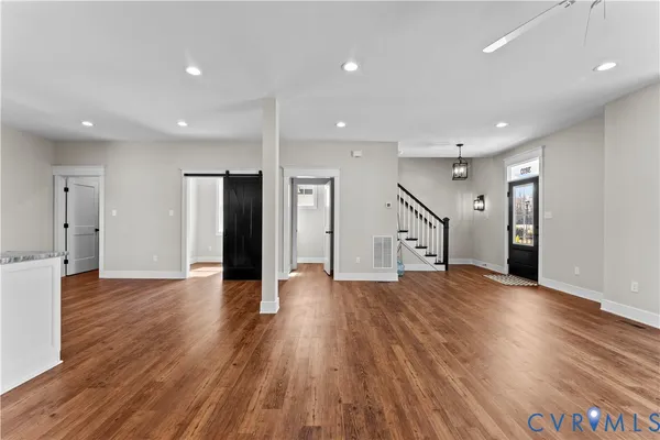 a kitchen with granite countertop a refrigerator cabinets and wooden floor