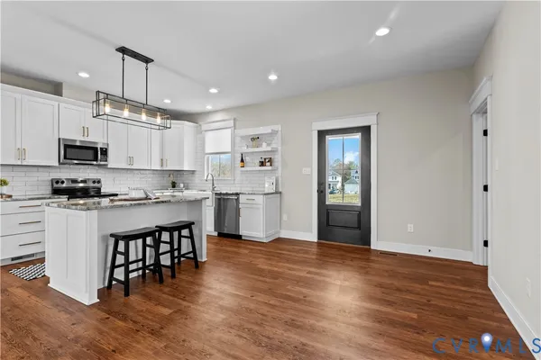 a kitchen with stainless steel appliances granite countertop a sink stove and cabinets