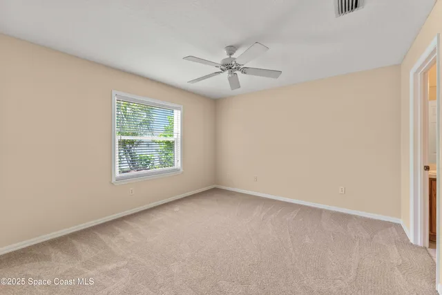 an empty room with a window and a fan
