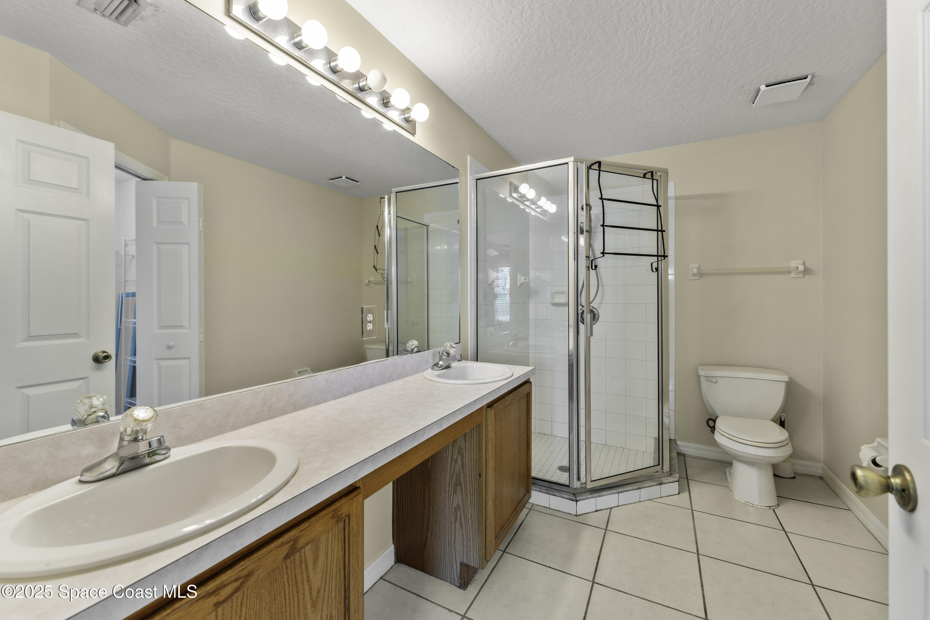 36 Sunset Street Satellite Beach, FL 32937 - Photo 18 of 45 a spacious bathroom with a granite countertop sink a toilet and a mirror