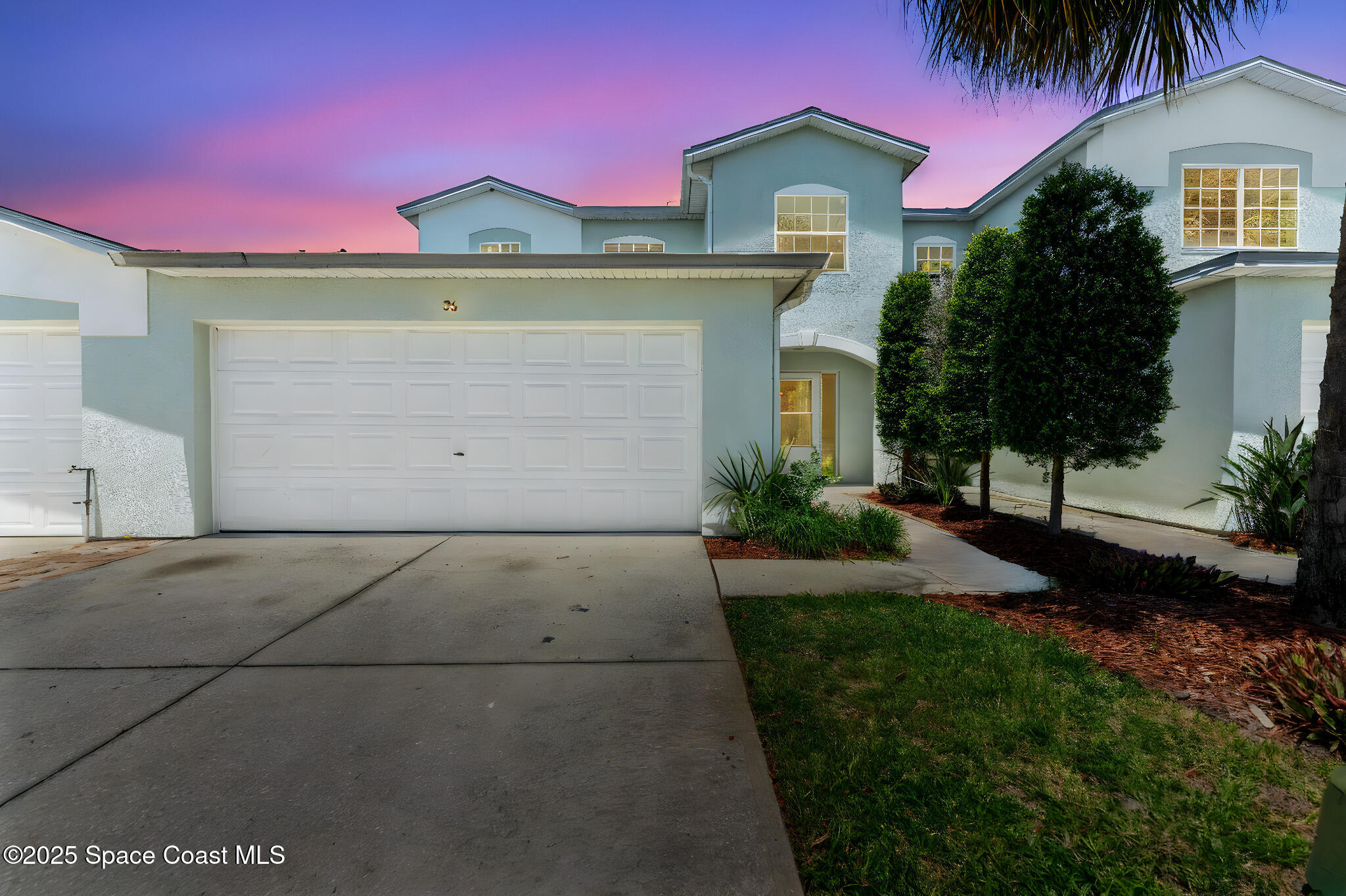 36 Sunset Street Satellite Beach, FL 32937 - Photo 2 of 45 a front view of a house with a garden and a garage