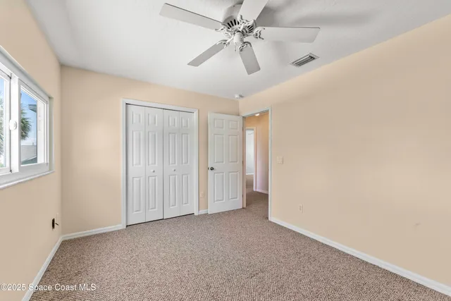 a view of a livingroom with a ceiling fan and window