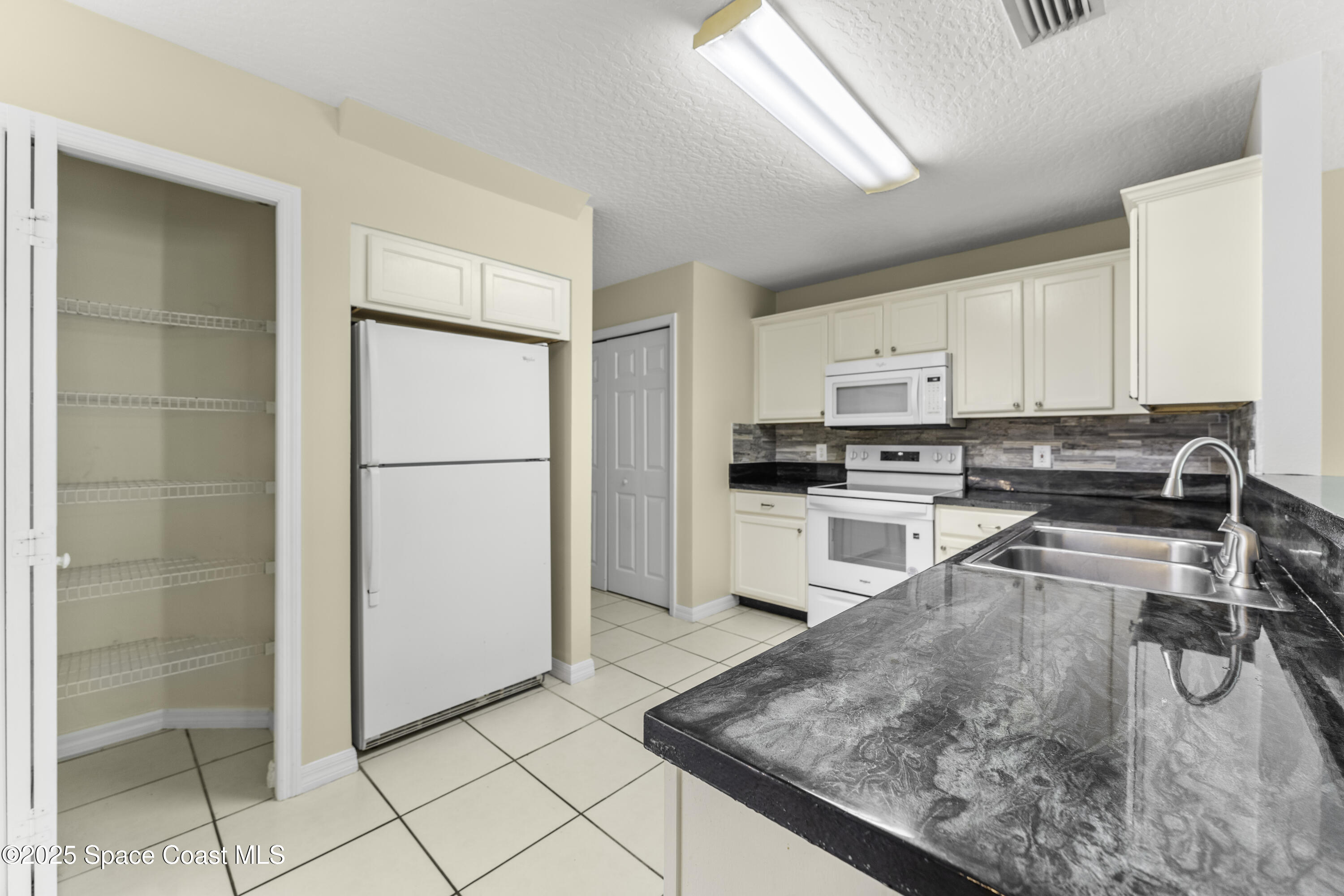 36 Sunset Street Satellite Beach, FL 32937 - Photo 7 of 45 a kitchen with stainless steel appliances granite countertop a refrigerator and a sink