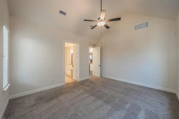 a view of an empty room with a chandelier fan