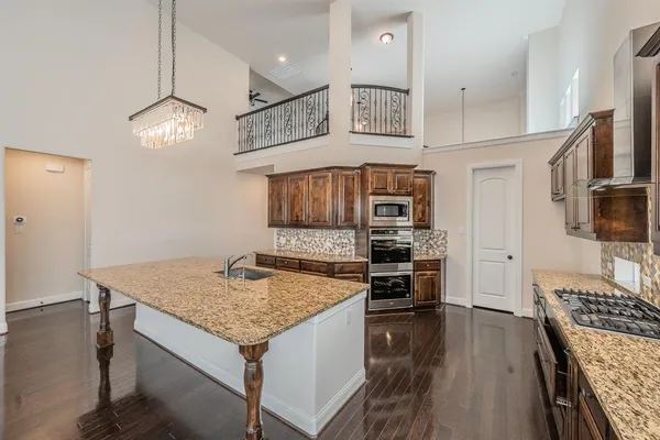 a kitchen with a stove center island and wooden floor