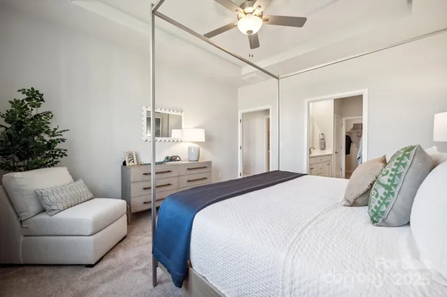 a bedroom with a bed couch and chandelier
