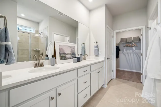a bathroom with a double vanity sink mirror and shower