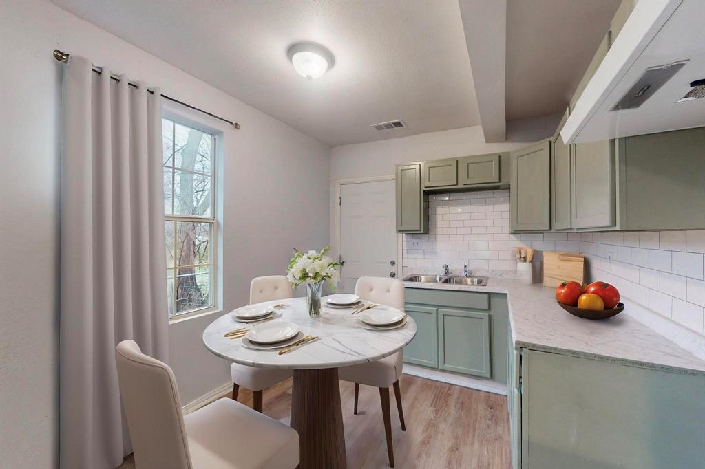 505 Oak Street Commerce, TX 75428 - Photo 12 of 28 a kitchen with a sink a table and chairs in it