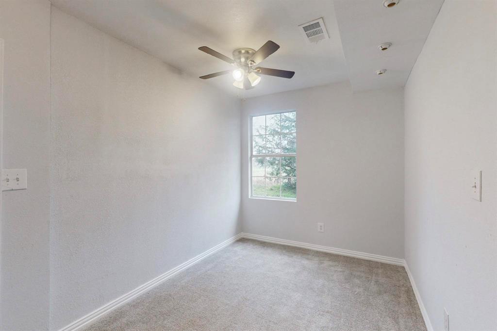 505 Oak Street Commerce, TX 75428 - Photo 23 of 28 an empty room with a window and a fan