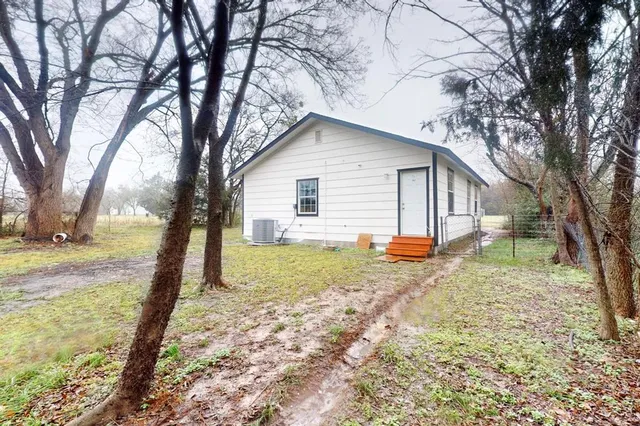 a view of a house with a yard and trees