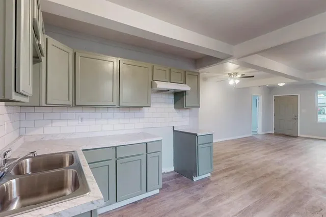 a kitchen with cabinets and wooden floor
