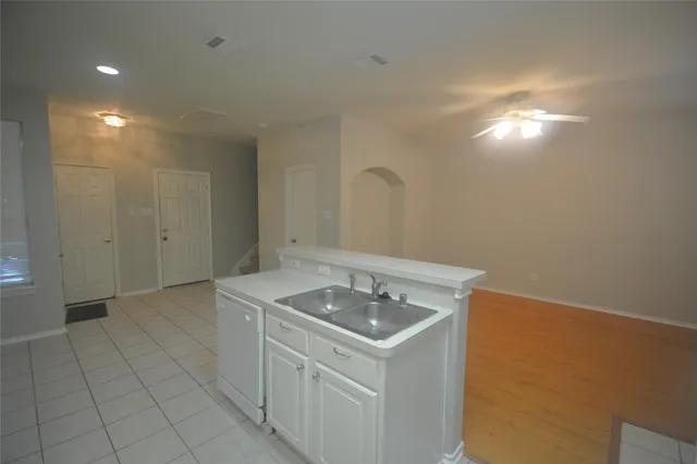 a view of a kitchen with a sink and dishwasher a refrigerator with white cabinets