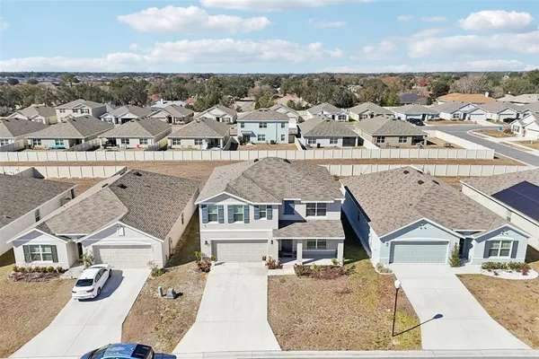 an aerial view of a house with a garden and lake view