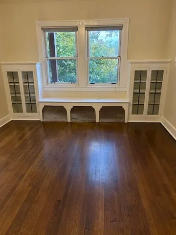 a view of a room with wooden floor and a window