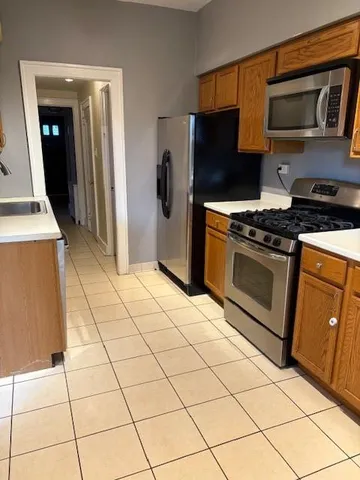 a kitchen with stainless steel appliances granite countertop a stove a refrigerator and a cabinets