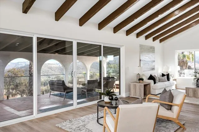 a large kitchen with granite countertop a stove a sink a dining table and chairs with wooden floor