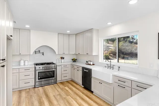 a living room with stainless steel appliances kitchen island granite countertop furniture and a wooden floor