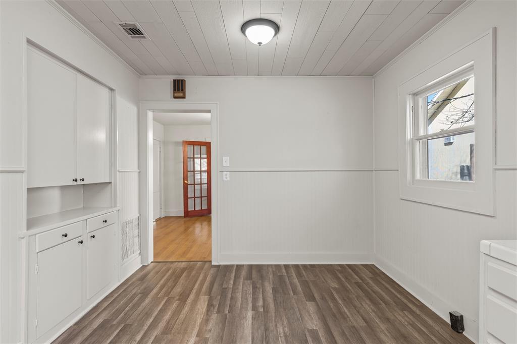 2912 Edmond Avenue Waco, TX 76707 - Photo 13 of 30 Unfurnished dining area with dark wood-type flooring, a wainscoted wall, and crown molding