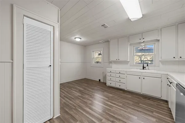 a kitchen with white cabinets and white appliances
