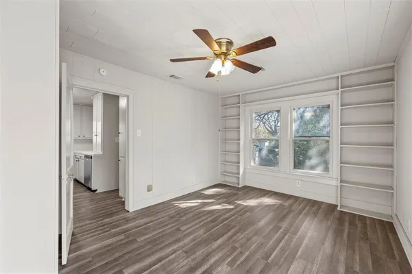 a view of empty room with wooden floor and window