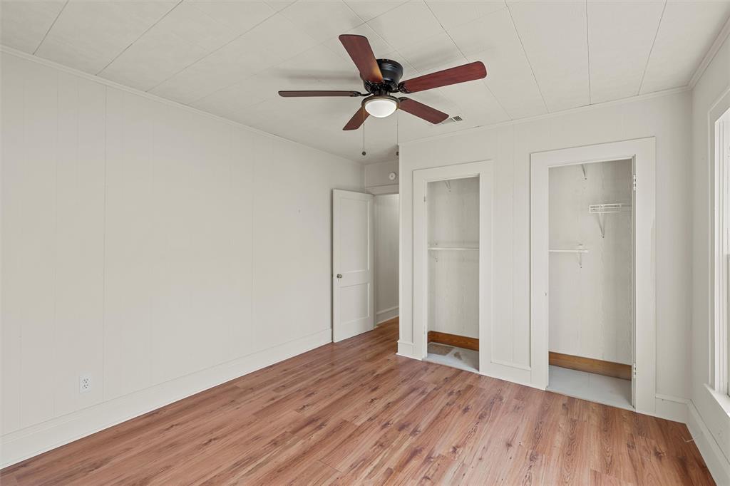 2912 Edmond Avenue Waco, TX 76707 - Photo 19 of 30 Unfurnished bedroom with multiple closets, wood finished floors, ceiling fan, and ornamental molding