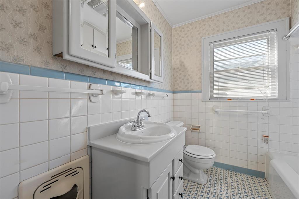 2912 Edmond Avenue Waco, TX 76707 - Photo 20 of 30 Bathroom with a wainscoted wall, vanity, wallpapered walls, tile patterned flooring, and tile walls