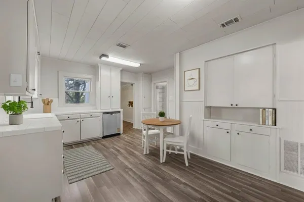 a kitchen with cabinets and wooden floor