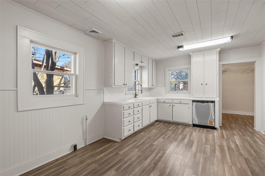 2912 Edmond Avenue Waco, TX 76707 - Photo 7 of 30 Kitchen with a wainscoted wall, white cabinetry, dishwasher, light wood-type flooring, and wooden ceiling