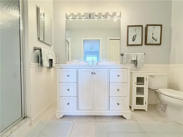 a bathroom with a granite countertop sink a toilet and mirror