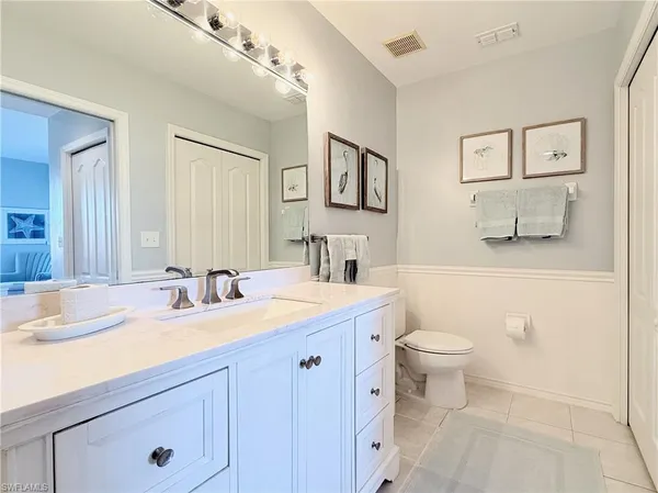 a bathroom with a granite countertop sink mirror vanity and toilet