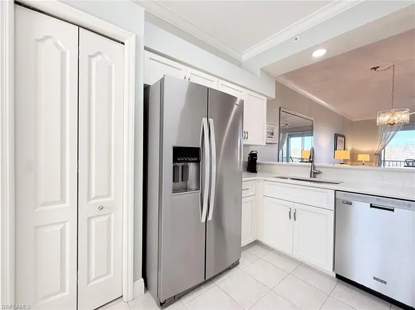 a kitchen with stainless steel appliances a refrigerator sink and white cabinets