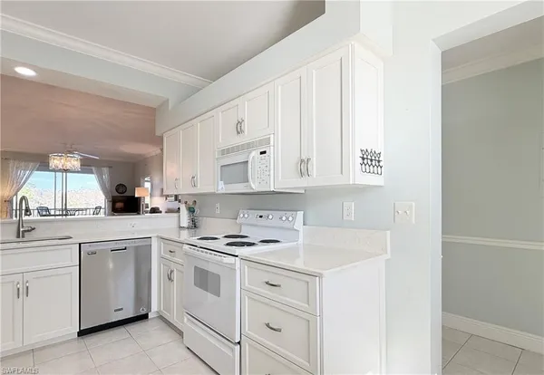 a kitchen with white cabinets and white appliances