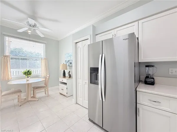 a kitchen with a refrigerator and white cabinets