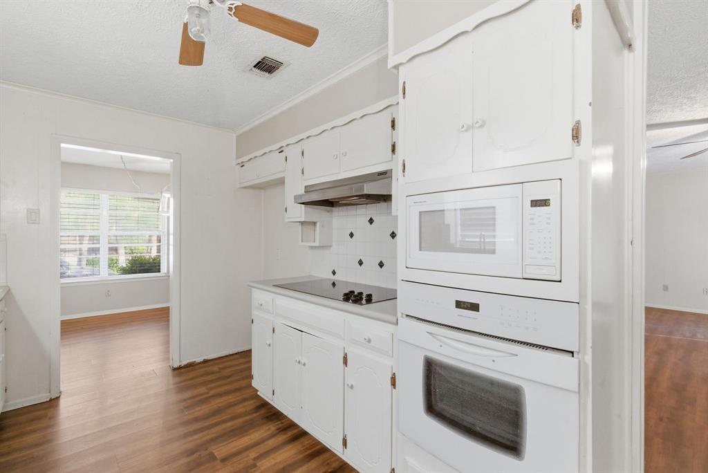 120 Timberlake Drive Azle, TX 76020 - Photo 12 of 32 a kitchen with white cabinets and white appliances