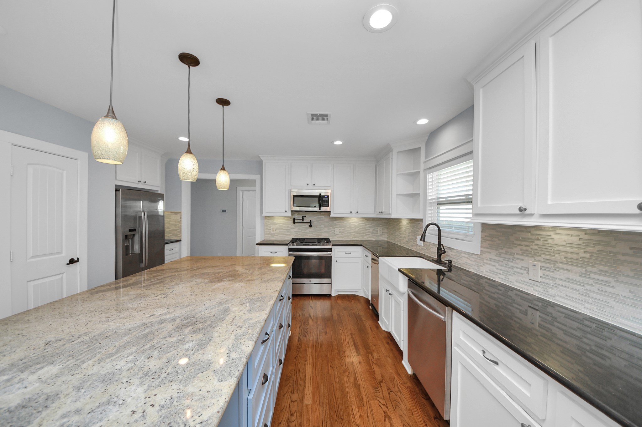 509 Vincent Street Houston, TX 77009 - Photo 12 of 39 a large kitchen with stainless steel appliances kitchen island granite countertop a stove a sink a refrigerator and a granite counter tops
