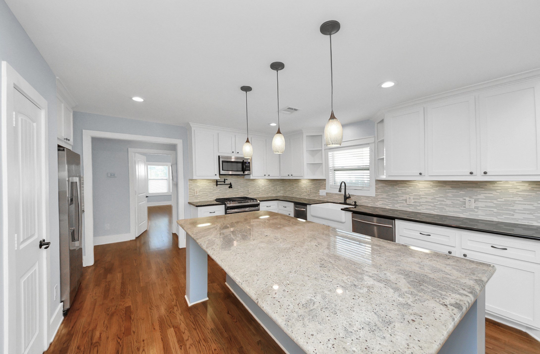509 Vincent Street Houston, TX 77009 - Photo 13 of 39 a large kitchen with kitchen island a stove a sink a refrigerator and wooden floor