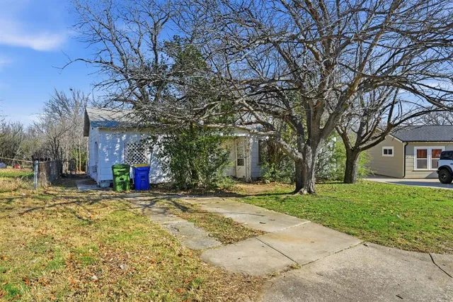 a view of a house with a yard and trees