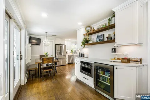 a kitchen with stainless steel appliances a stove a sink and a refrigerator with wooden floor