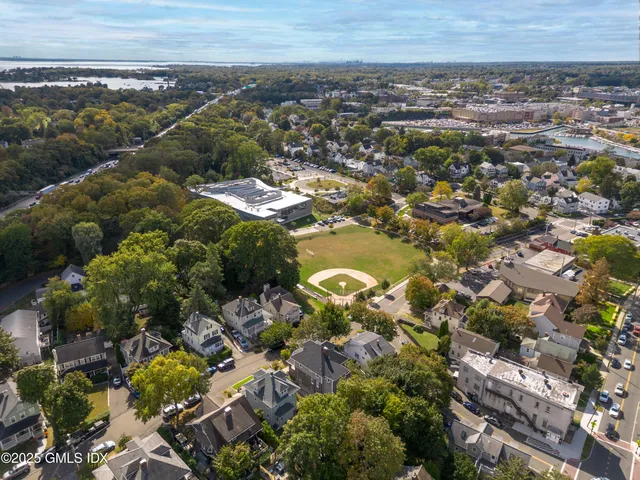 an aerial view of residential house with yard and mountain view in back
