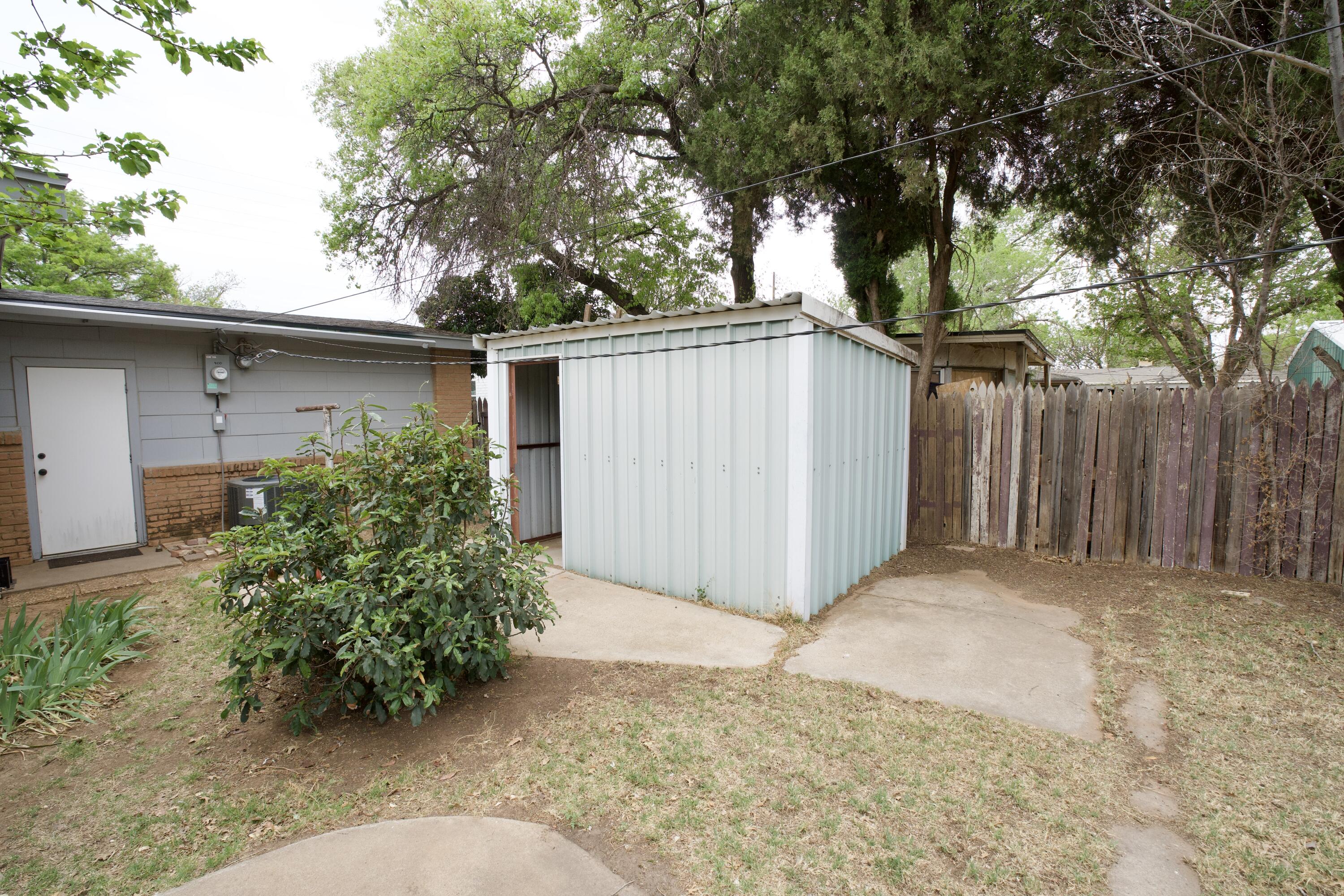 3412 42nd Street Lubbock, TX 79413 - Photo 15 of 17 a backyard of a house with plants and trees