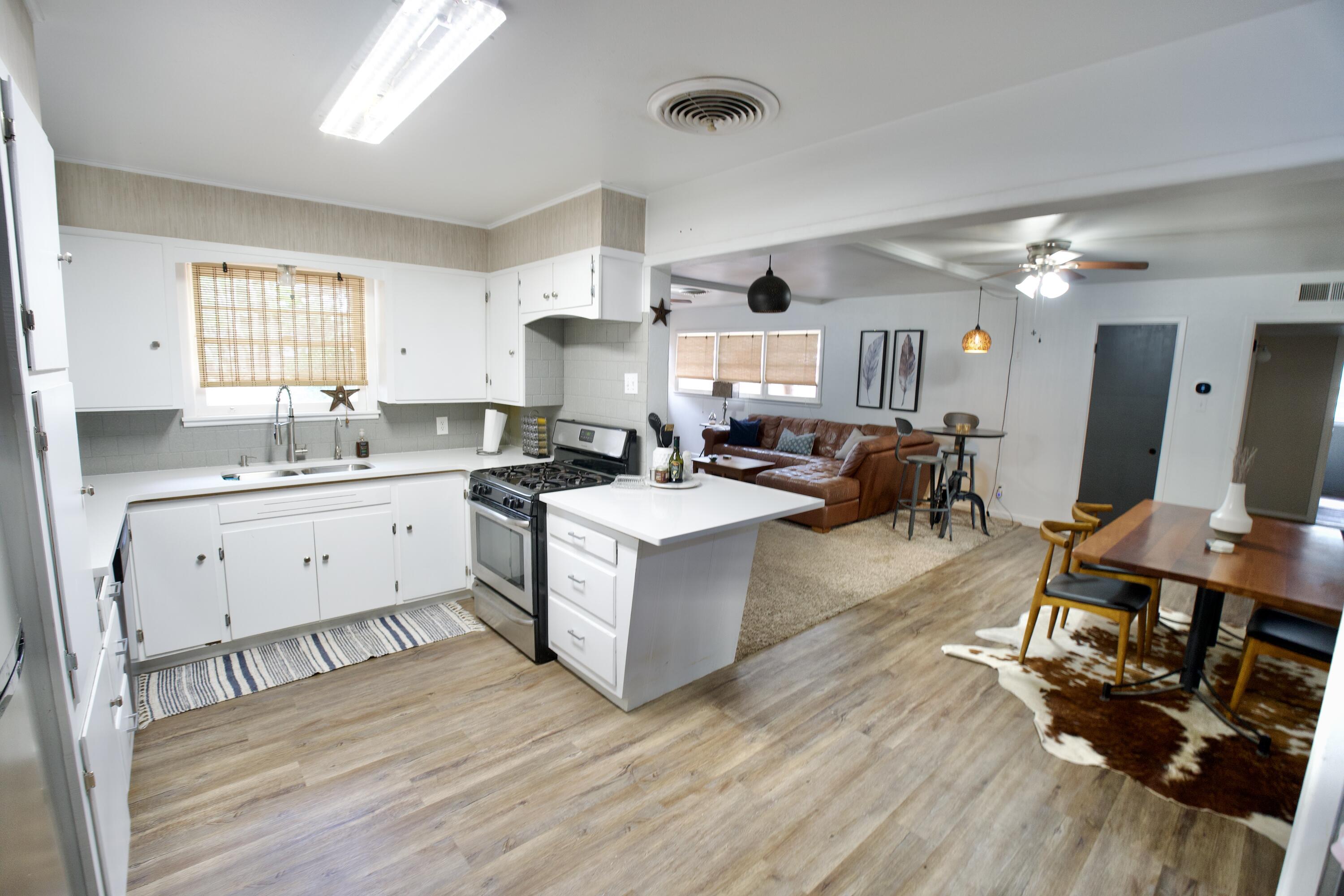 3412 42nd Street Lubbock, TX 79413 - Photo 3 of 17 a large white kitchen with a large window and stainless steel appliances