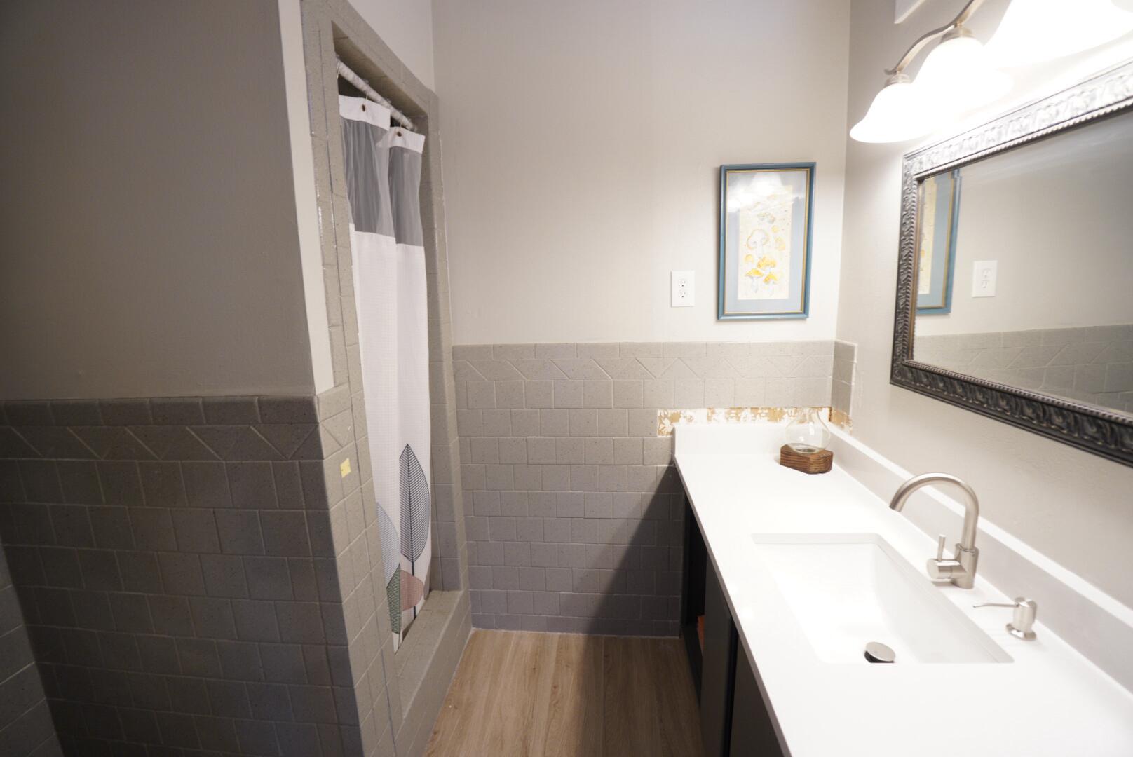 3412 42nd Street Lubbock, TX 79413 - Photo 9 of 17 a bathroom with a sink a toilet and mirror